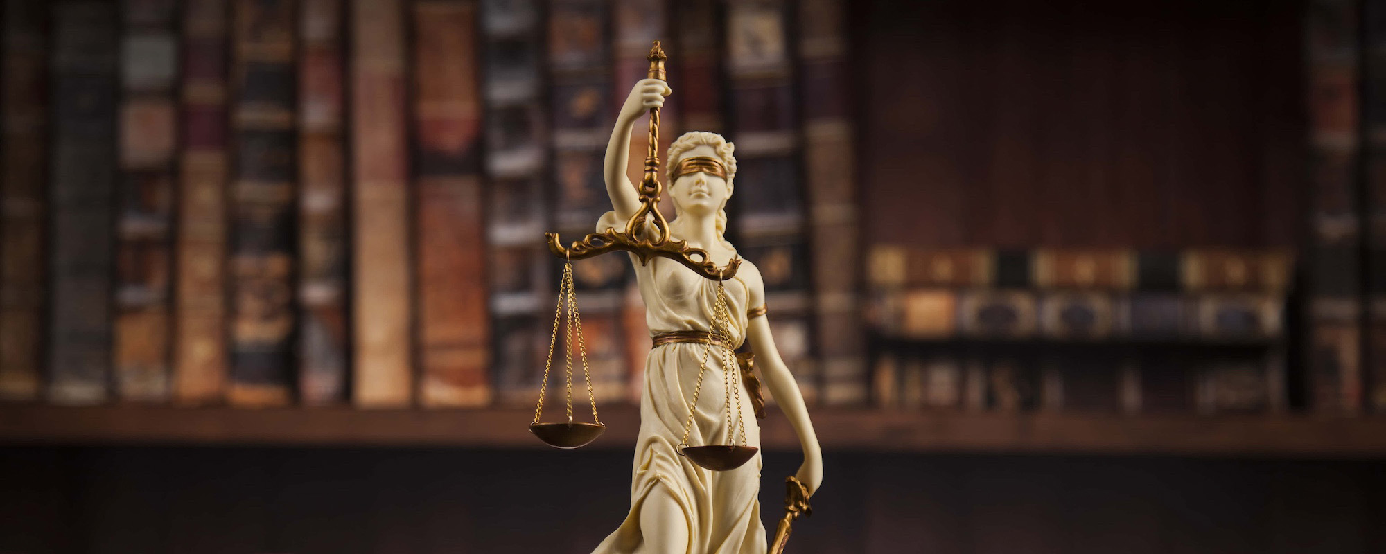 Antique statue of justice law books background
