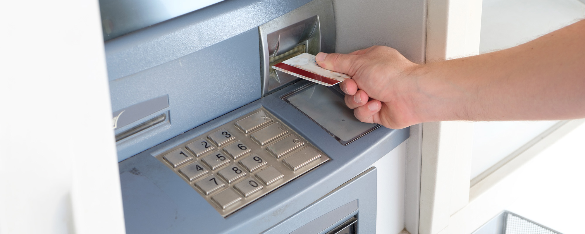 Man hand inserting a credit card in an atm