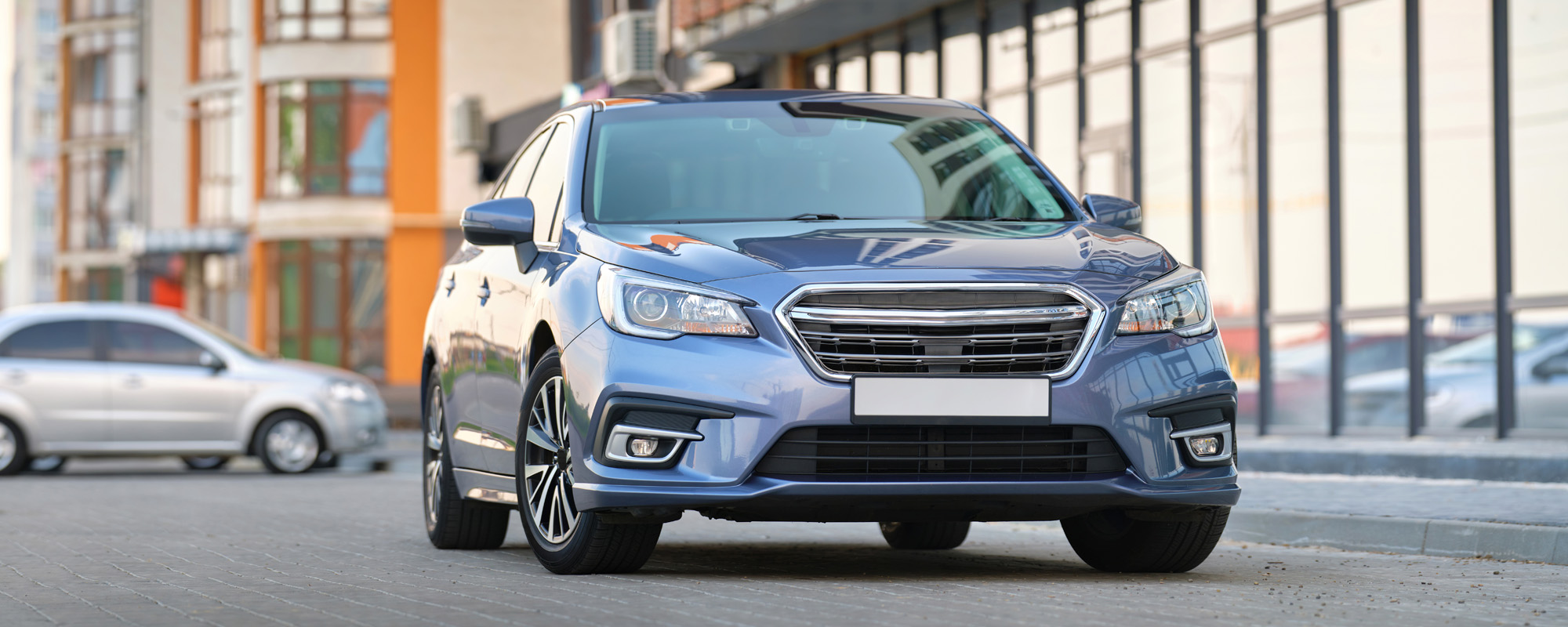 ront view of new car parked on city street side