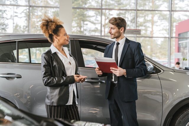 car salesman talking to woman